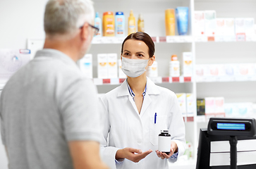 Image showing apothecary in mask and senior customer at pharmacy