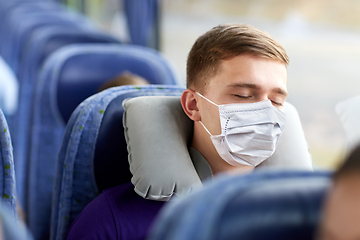 Image showing man in mask sleeping in travel bus with pillow