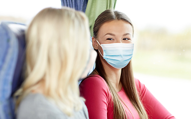 Image showing young women in masks sitting in travel bus