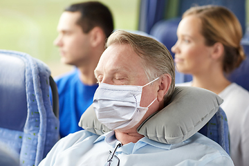 Image showing senior man in mask sleeping in travel bus