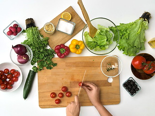 Image showing woman chopping tomato with knife at kitchen