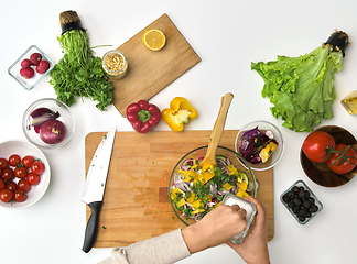 Image showing hands cooking vegetable salad on kitchen table