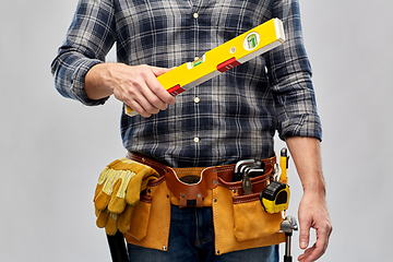 Image showing male builder with level and working tools on belt