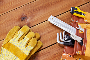 Image showing different work tools in belt on wooden boards