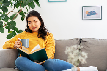 Image showing woman reading book and drinking coffee at home