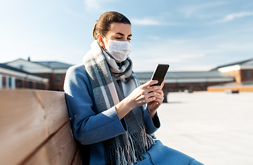 Image showing woman in face mask with smartphone in city