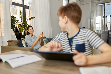 Image showing mother with smartphone talking to son at home