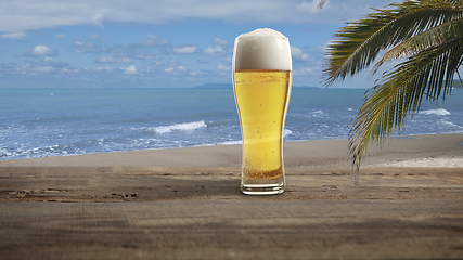 Image showing Glass with cold beer with sea or ocean beach on background