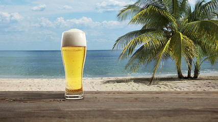 Image showing Glass with cold beer with sea or ocean beach on background