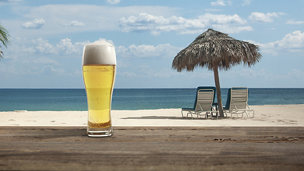 Image showing Glass with cold beer with sea or ocean beach on background