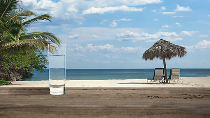 Image showing Glass of cold mineral water on the table of the beach background