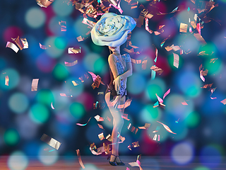 Image showing Young female dancer with huge floral hat in neon light on gradient background in flying confetti