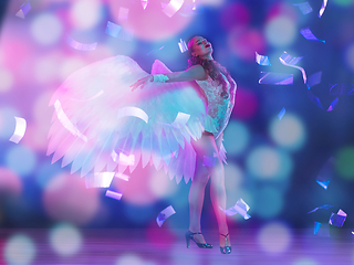 Image showing Young female dancer with angel\'s wings in neon light on black background in flying confetti