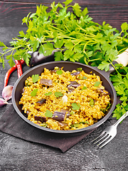 Image showing Bulgur with eggplant in pan on wooden board