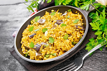 Image showing Bulgur with eggplant in pan on wooden table