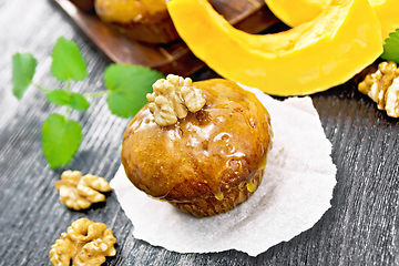 Image showing Cupcake pumpkin with orange glaze and walnuts on parchment