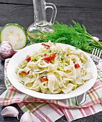 Image showing Fettuccine with zucchini and hot peppers in plate on black board