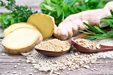 Image showing Ginger ground and flakes in spoons with root on board