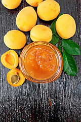 Image showing Jam apricot in jar on dark board top