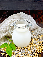 Image showing Milk soy in jug with soybeans and leaf on board