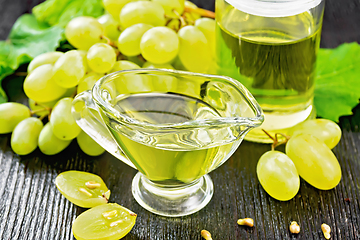 Image showing Oil grape in gravy boat on board