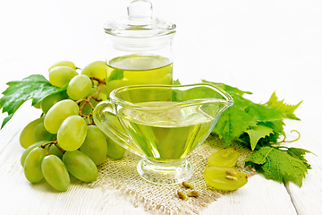 Image showing Oil grape in gravy boat on light board