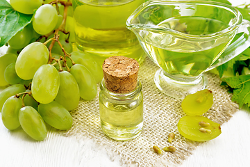 Image showing Oil grape in vial on board