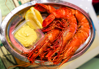 Image showing Jumbo shrimps with lemon and sauce on metal plate 