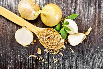 Image showing Onion flakes in spoon on dark board top