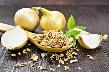 Image showing Onion flakes in spoon on dark board