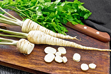 Image showing Parsley root chopped with knife on dark board