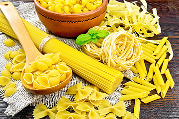 Image showing Pasta different with basil on dark board