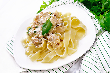 Image showing Pasta with salmon in cream on wooden board