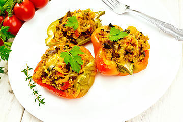 Image showing Pepper stuffed with mushrooms and couscous in plate on light boa