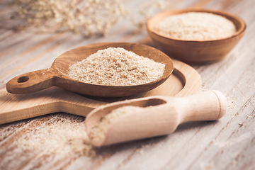 Image showing Isabgol - heap of psyllium husk in wooden bowl on wooden table table