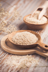 Image showing Isabgol - heap of psyllium husk in wooden bowl on wooden table table