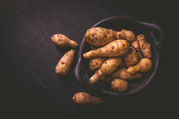 Image showing Raw topinambour in bowl on wooden background