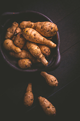 Image showing Raw topinambour in bowl on wooden background