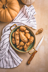 Image showing Raw topinambour with pumpkins in bowl on kitchen table