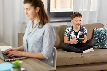 Image showing boy with gamepad playing video game at home