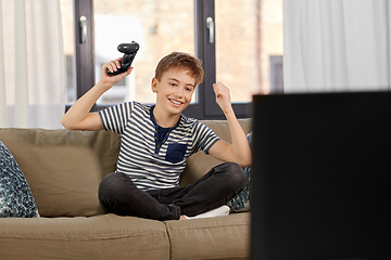 Image showing happy boy with gamepad playing video game at home