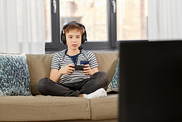 Image showing boy with gamepad playing video game at home