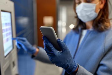 Image showing woman in mask with smartphone at parcel machine