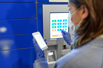 Image showing woman in mask with smartphone at parcel machine