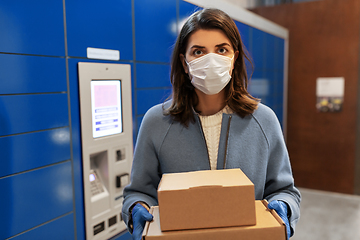 Image showing woman in mask with boxes at parcel machine