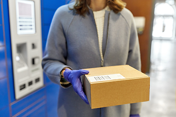 Image showing woman in gloves with boxes at parcel machine