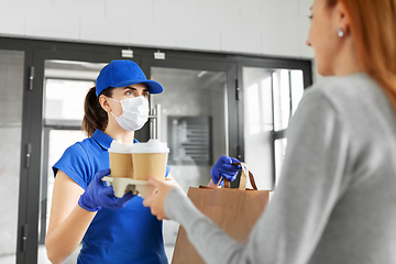 Image showing delivery girl in mask giving paper bag to customer