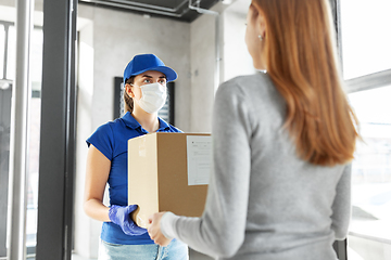 Image showing delivery girl in face mask giving parcel to woman