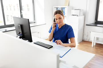 Image showing doctor with computer calling on phone at hospital