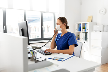 Image showing doctor with computer calling on phone at hospital